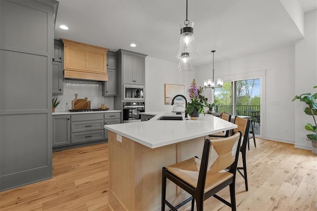 14574 Aurora Ln, Basehor, KS 66007 - kitchen featuring gray cabinetry, a sink, backsplash, light wood finished floors, and cooktop
