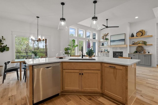 14574 Aurora Ln, Basehor, KS 66007 - kitchen featuring stainless steel dishwasher, a sink, a ceiling fan, a fireplace, and light countertops