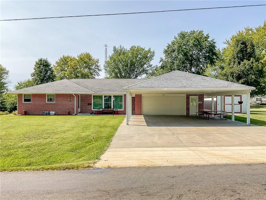 view of front facade with a garage, a front lawn, and a carport