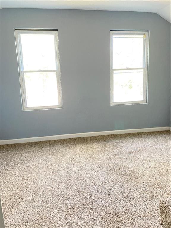 unfurnished room featuring carpet floors and vaulted ceiling