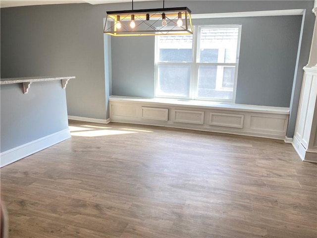 unfurnished dining area with light hardwood / wood-style floors and a notable chandelier