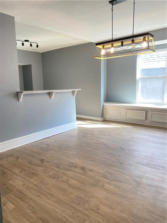 spare room featuring a textured ceiling and light hardwood / wood-style flooring