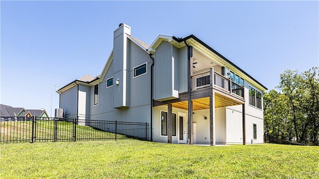 rear view of property with a balcony and a lawn