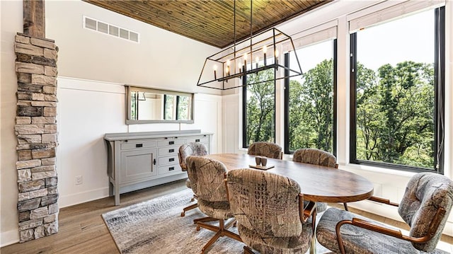 dining area featuring wood ceiling, light hardwood / wood-style flooring, and an inviting chandelier