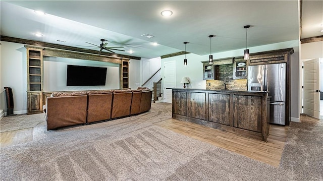 kitchen with dark brown cabinets, stainless steel refrigerator with ice dispenser, light hardwood / wood-style floors, a center island, and ceiling fan