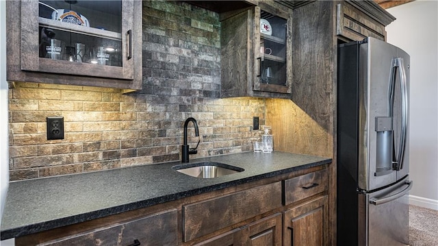 kitchen featuring stainless steel fridge, dark brown cabinets, tasteful backsplash, and sink