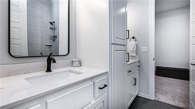 bathroom featuring tiled shower, vanity, and tile patterned floors