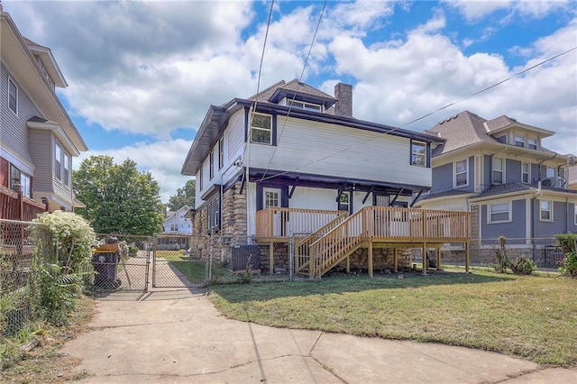 rear view of property with a yard and a wooden deck