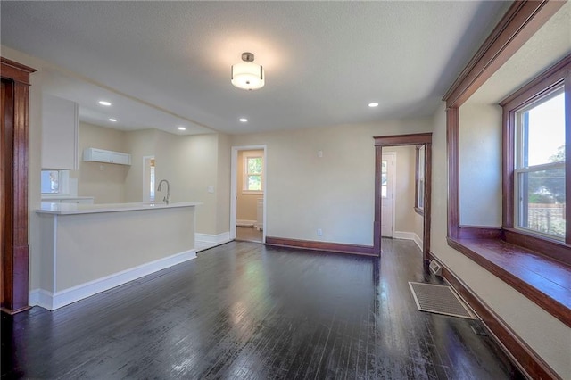 unfurnished living room with dark hardwood / wood-style flooring and a wealth of natural light