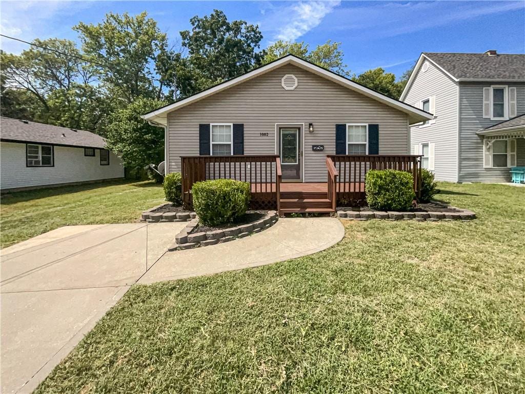 bungalow-style house with a wooden deck and a front yard