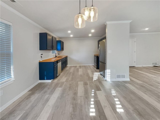 kitchen with stainless steel appliances, an inviting chandelier, butcher block counters, and light hardwood / wood-style flooring