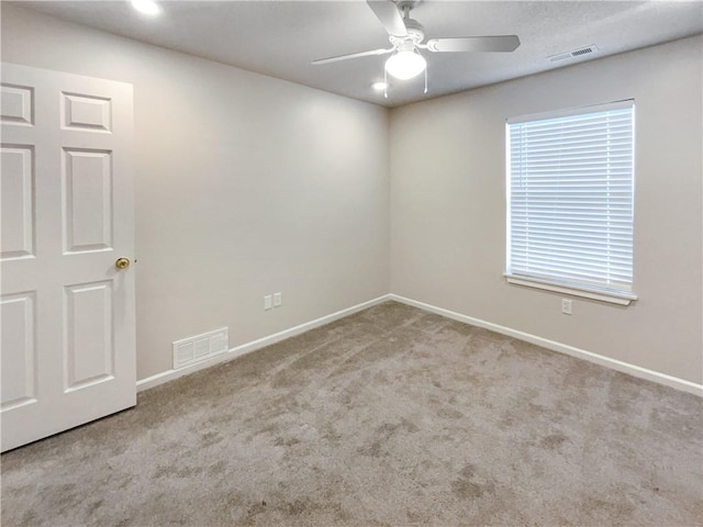 empty room with ceiling fan and carpet