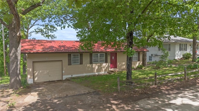 ranch-style house featuring driveway, a garage, and metal roof