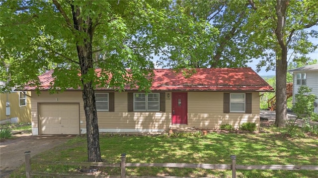 single story home featuring fence, driveway, an attached garage, and a front lawn