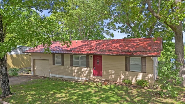 ranch-style house with driveway, metal roof, a garage, and a front lawn