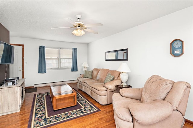 living room with a baseboard radiator, hardwood / wood-style flooring, and ceiling fan