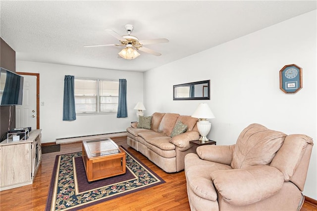 living room featuring a textured ceiling, a baseboard radiator, wood finished floors, and a ceiling fan