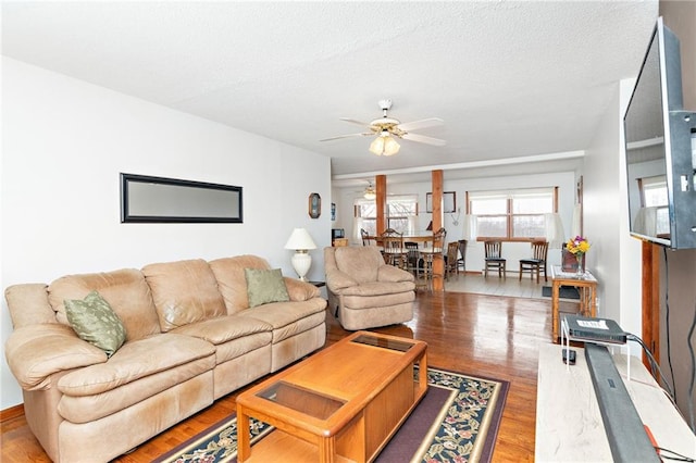 living room featuring a textured ceiling, hardwood / wood-style flooring, and ceiling fan