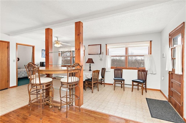 dining space with ceiling fan, beam ceiling, a textured ceiling, and light hardwood / wood-style flooring