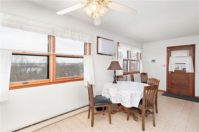 dining room with a baseboard heating unit and ceiling fan