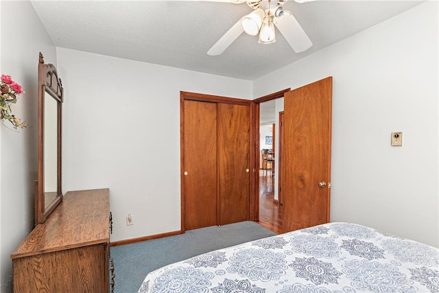 bedroom featuring baseboards, a textured ceiling, carpet flooring, and a ceiling fan