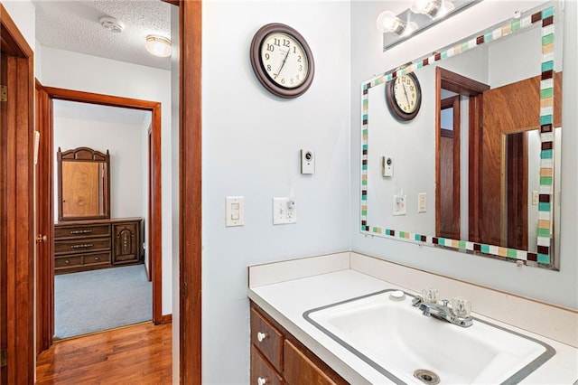 bathroom with vanity, a textured ceiling, and wood-type flooring