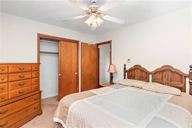 bedroom with a closet, ceiling fan, and light colored carpet