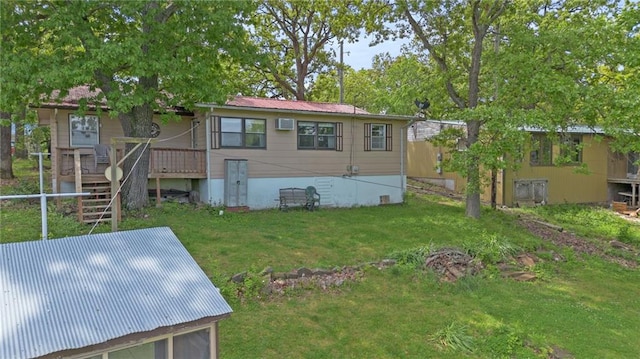 rear view of property with stairs, metal roof, a wall unit AC, and a yard