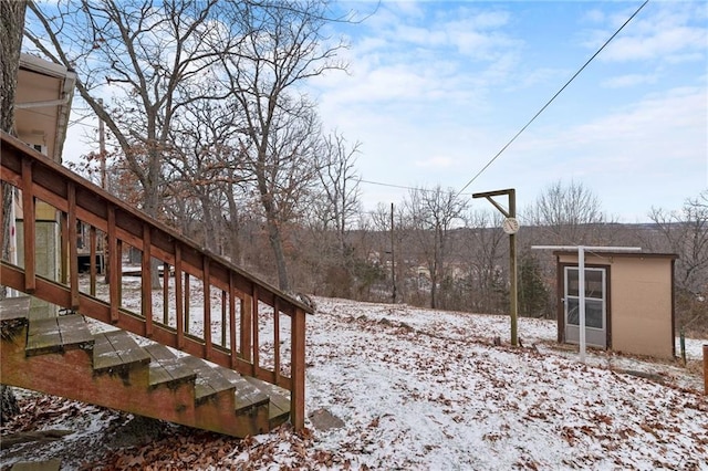 yard covered in snow featuring an outbuilding and stairway