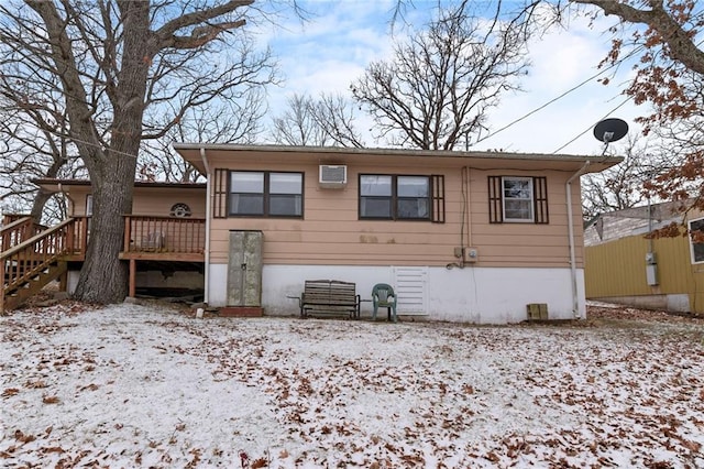 snow covered property with stairs and a wooden deck