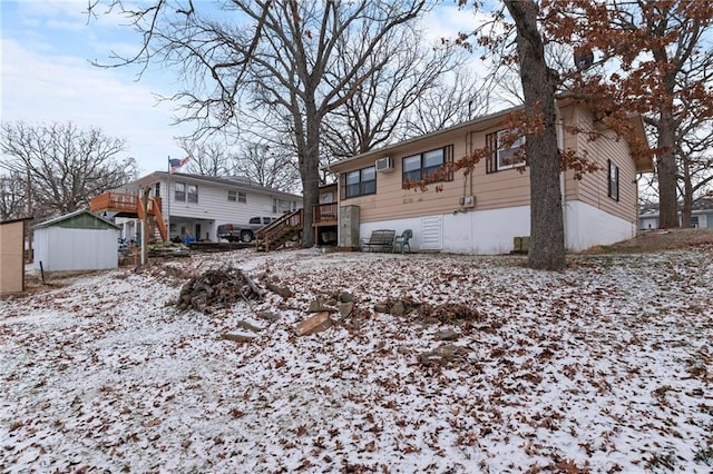 snow covered property with stairway