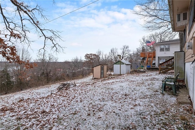 yard layered in snow featuring a storage shed