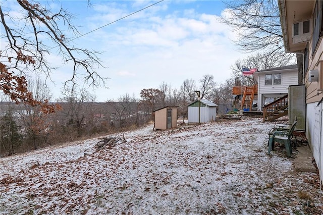 yard covered in snow featuring an outbuilding and a shed
