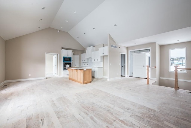 unfurnished living room featuring lofted ceiling