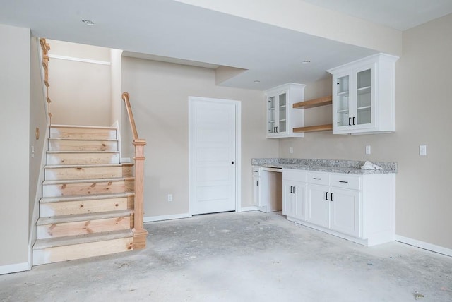 kitchen with white cabinetry, stainless steel dishwasher, and light stone counters