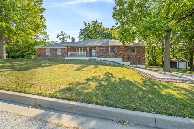 single story home with an outbuilding, a garage, and a front lawn