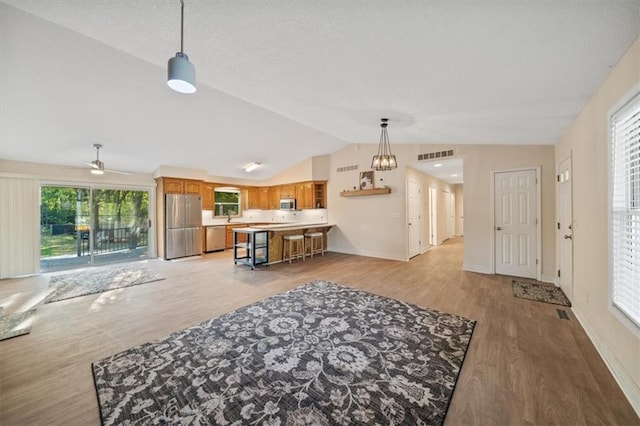 interior space featuring lofted ceiling, sink, ceiling fan, and light hardwood / wood-style floors