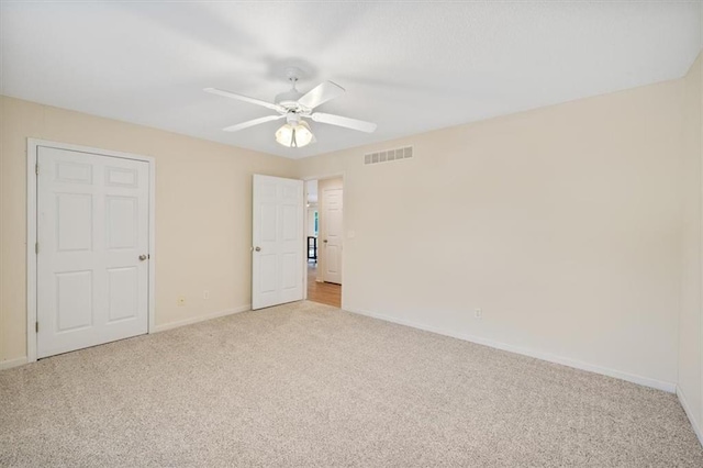 unfurnished bedroom with ceiling fan and light colored carpet