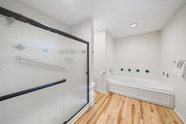 bathroom with toilet, hardwood / wood-style flooring, and plus walk in shower