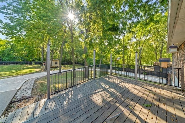 wooden deck with a yard and a shed