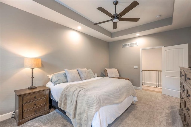 bedroom featuring a tray ceiling, ceiling fan, and light colored carpet