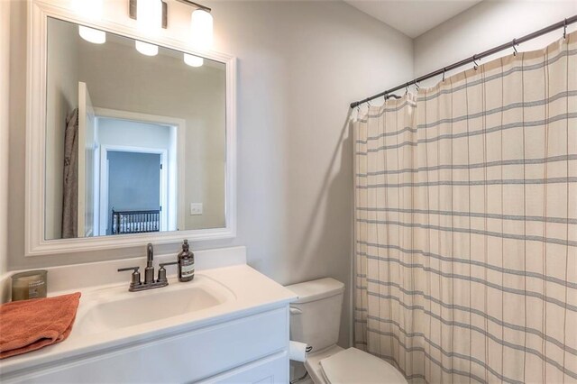 bathroom featuring curtained shower, vanity, and toilet