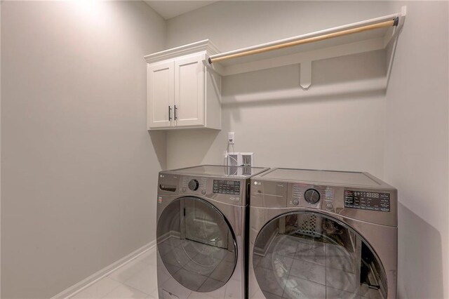 laundry room with washing machine and clothes dryer and cabinets