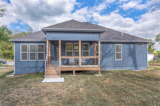 rear view of house with a lawn and covered porch