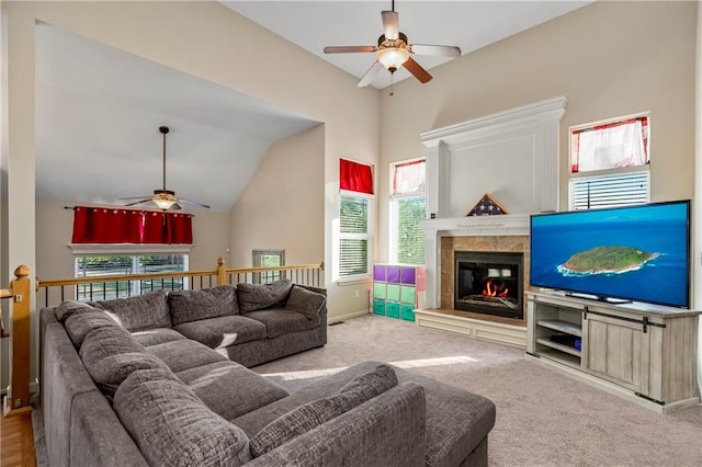 carpeted living room with ceiling fan, lofted ceiling, and a tiled fireplace