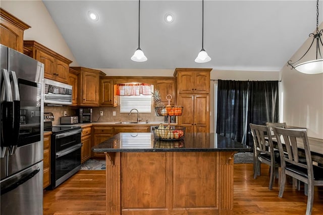 kitchen featuring a kitchen island, sink, stainless steel appliances, and tasteful backsplash