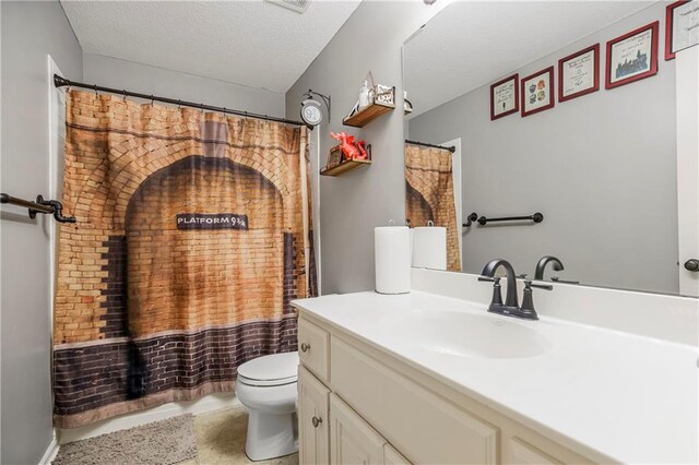 bathroom with vanity, a textured ceiling, and toilet