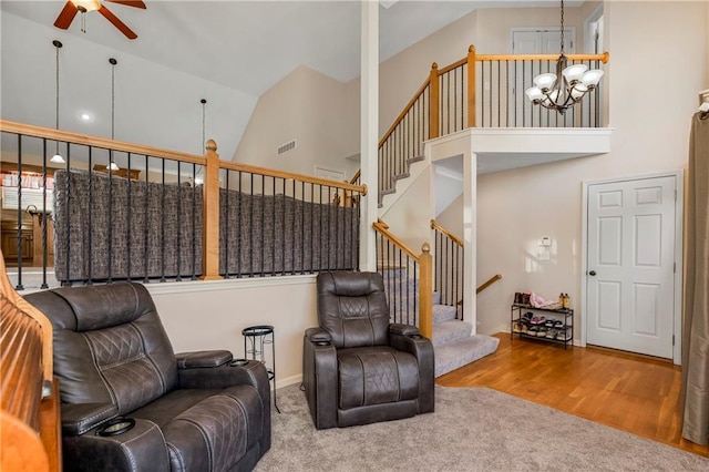8500 NE 99th Ter, Kansas City, MO 64157 - living room with ceiling fan with notable chandelier, wood-type flooring, and high vaulted ceiling