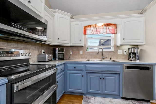 8500 NE 99th Ter, Kansas City, MO 64157 - kitchen with sink, appliances with stainless steel finishes, white cabinets, blue cabinets, and decorative backsplash