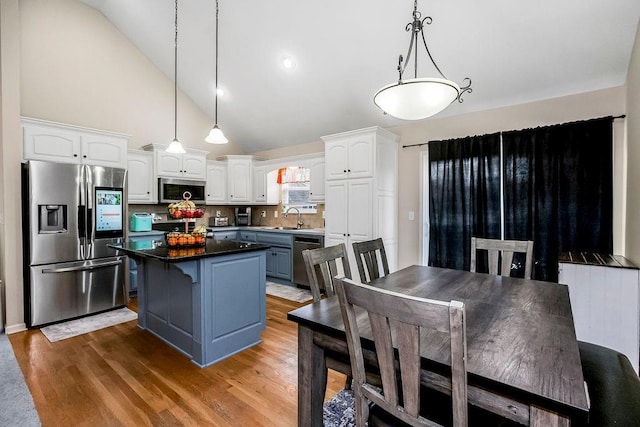 8500 NE 99th Ter, Kansas City, MO 64157 - kitchen with hanging light fixtures, a kitchen island, appliances with stainless steel finishes, and white cabinets